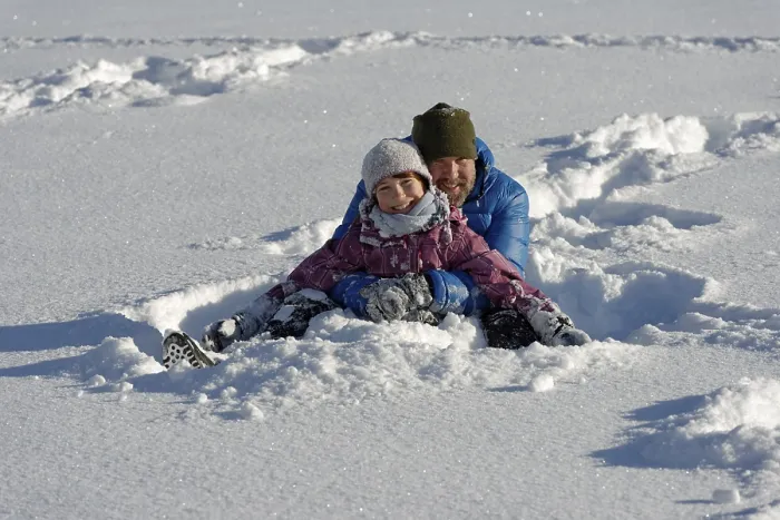 Framed Print : Father and daughter sitting in the deep snow