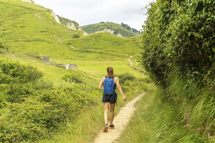 Framed Print : Female tourist walking on a path surrounded by lush vegetation