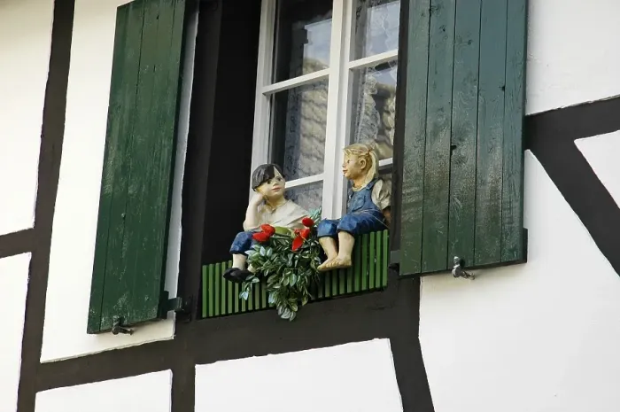 Framed Print : Figures of a boy and a girl in front of a window