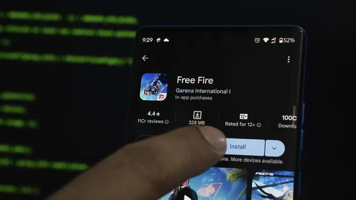 Framed Print : Finger pointing at Free Fire app store page on a smartphone with a dark background Framed Print : Finger pointing at Free Fire app store page on a smartphone with a dark background