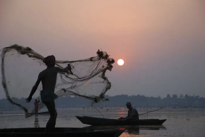 Framed Print : Fisherman in boat throwing net in silhouette Framed Print : Fisherman in boat throwing net in silhouette