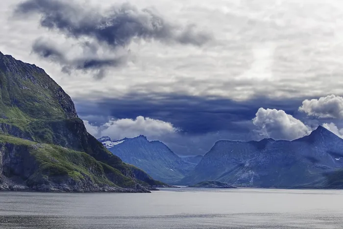 Framed Print : A fjord surrounded by green mountains under a dramatic cloudy sky