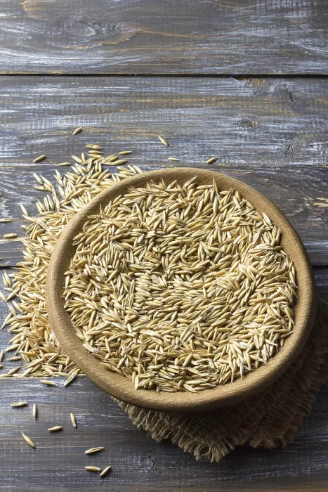Framed Print : Food, Close-up of raw oat grains in a wooden bowl placed on burlap fabric