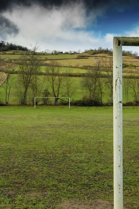 Framed Print : A football field is set against rolling hills and trees Framed Print : A football field is set against rolling hills and trees