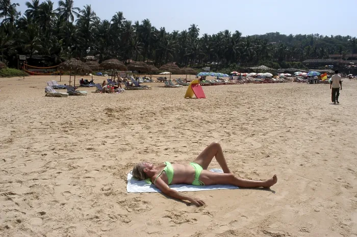 Framed Print : A foreign tourist enjoying sun bath on the Sinquerim beach of Goa