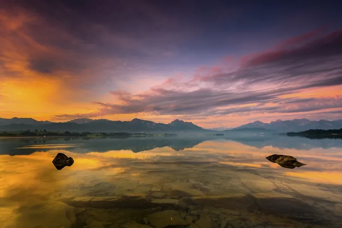 Framed Print : Forggensee with reflection of the cloudy sky and the Allgaeuer mountains in the background at sunrise Framed Print : Forggensee with reflection of the cloudy sky and the Allgaeuer mountains in the background at sunrise