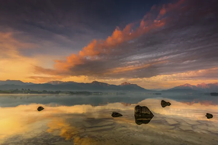 Framed Print : Forggensee with reflection of the cloudy sky and the Allgaeuer mountains in the background at sunrise Framed Print : Forggensee with reflection of the cloudy sky and the Allgaeuer mountains in the background at sunrise