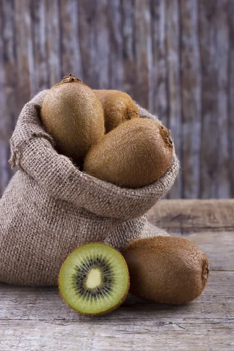 Framed Print : Fresh kiwi in burlap sack on old rustic wooden table