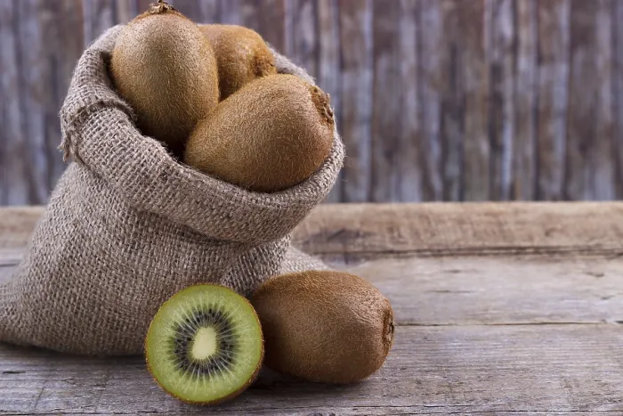Framed Print : Fresh kiwi in a sack on an old wooden board
