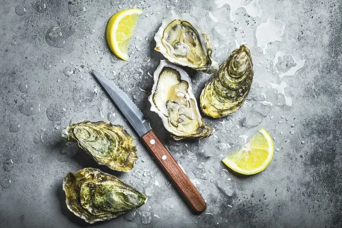 Framed Print : Fresh oysters on ice, knife, lemon wedges