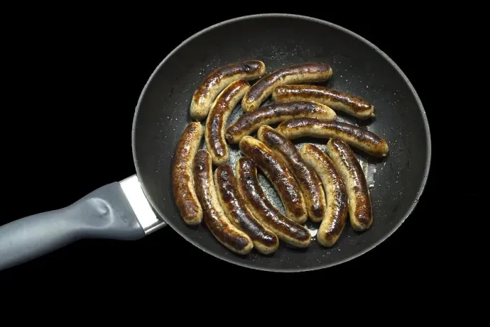 Framed Print : Freshly roasted Nuremberg sausages in a pan