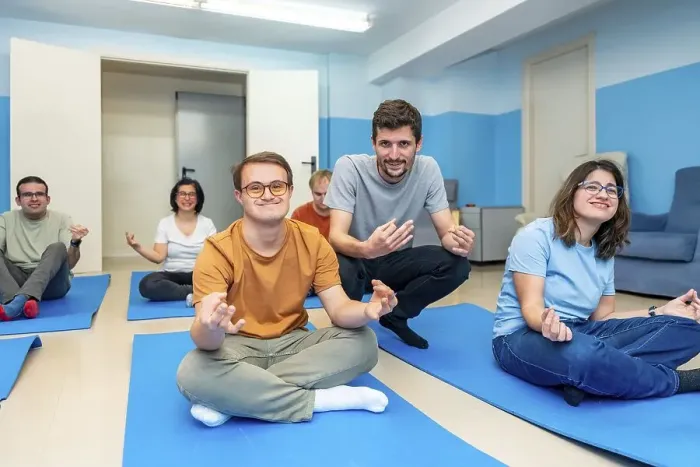 Framed Print : Friendly male yoga instructor directing a class with people with special needs and down syndrome