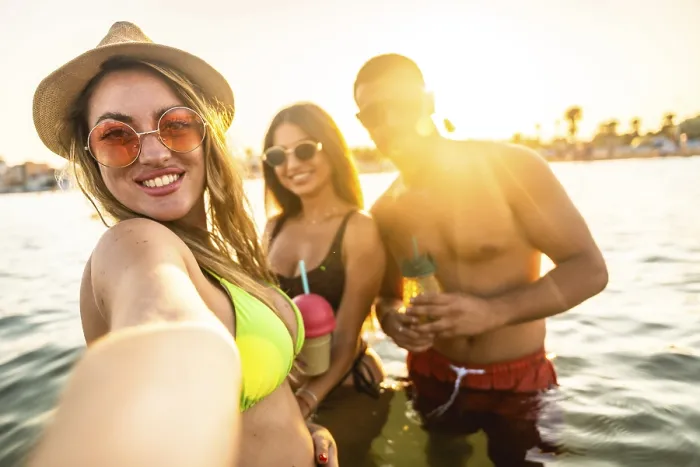 Framed Print : Three friends are taking a selfie while enjoying drinks in the sea during a beach party at sunset Framed Print : Three friends are taking a selfie while enjoying drinks in the sea during a beach party at sunset