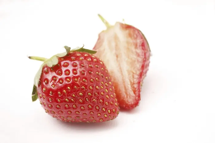 Framed Print : Fruit, Strawberry Fragaria Ananassa one full and one half on white background