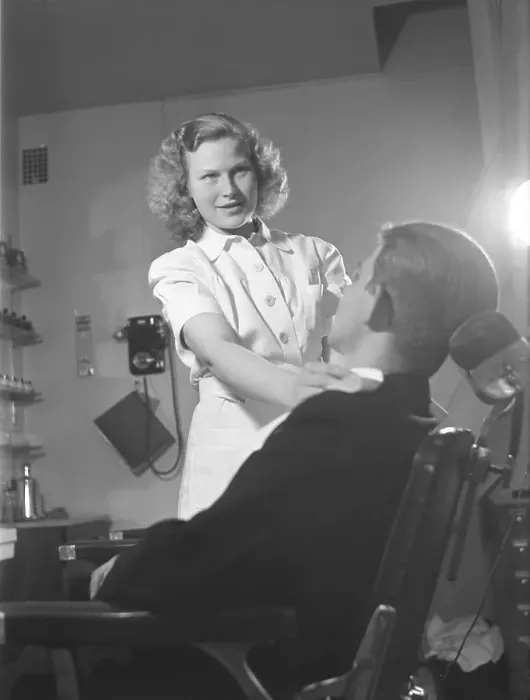 Framed Print : Getting a shave in the 1940s. A young woman in a barber shop