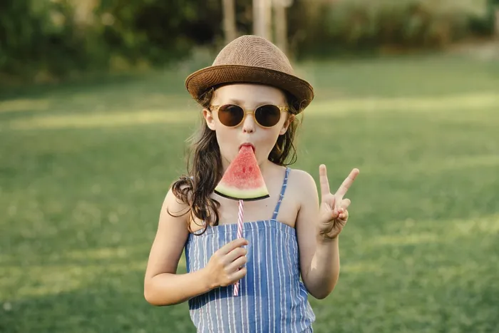 Framed Print : Girl eats watermelon on a stick