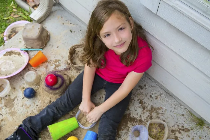 Framed Print : Girl playing with mud in a messy soil smiling portrait looing from high point Framed Print : Girl playing with mud in a messy soil smiling portrait looing from high point