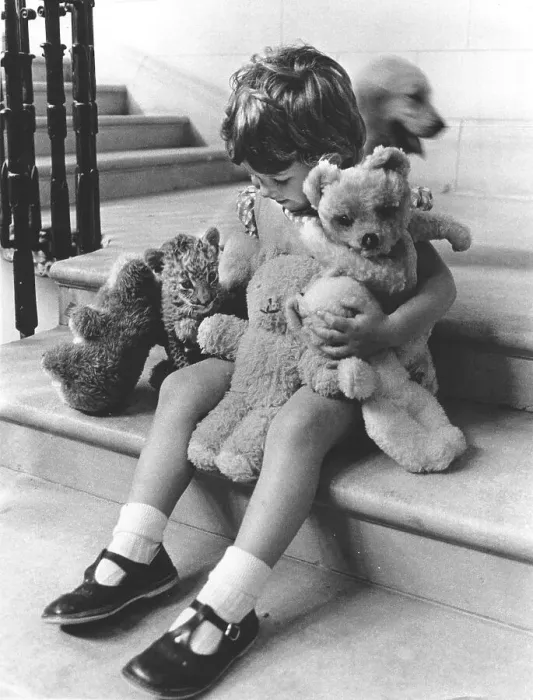 Framed Print : Girl plays with a baby predator and stuffed animals