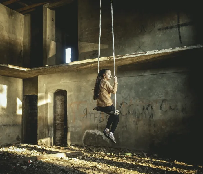 Framed Print : Girl rocking on a swing in a destroyed building on the seafront in Okhamchira