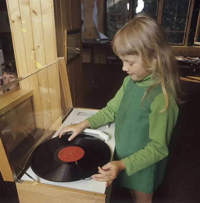 Framed Print : A girl is standing at a gramophone that is going to play an LP with Klas Klaettermus