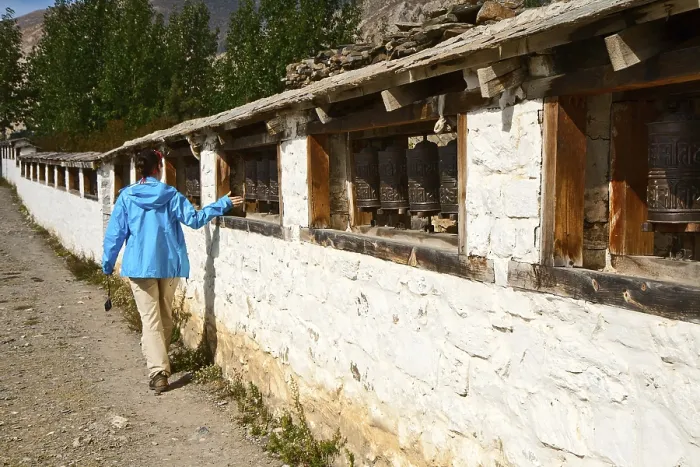 Framed Print : Girl turns prayer wheel in Muktinath temple, Nepal