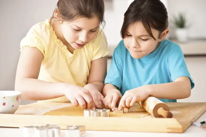 Framed Print : Two girls baking Christmas cookies