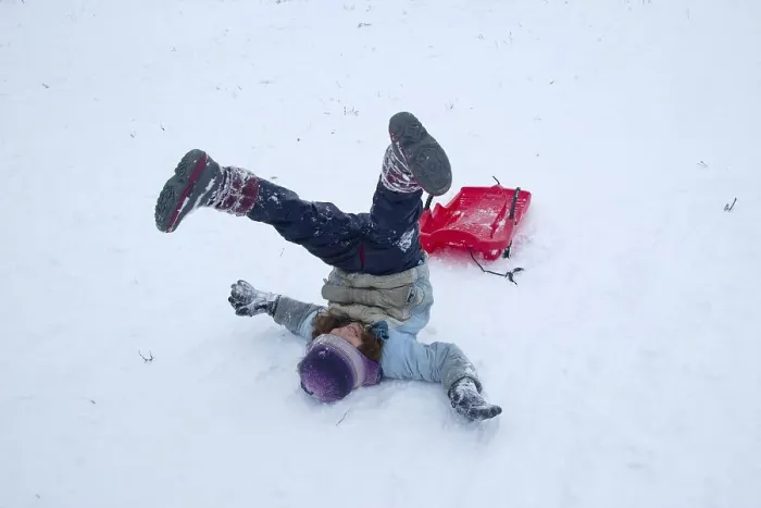 Framed Print : Girls rolling in the snow while sledding