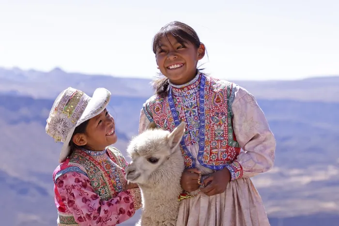 Framed Print : Two girls in traditional dress with an alpaca Framed Print : Two girls in traditional dress with an alpaca