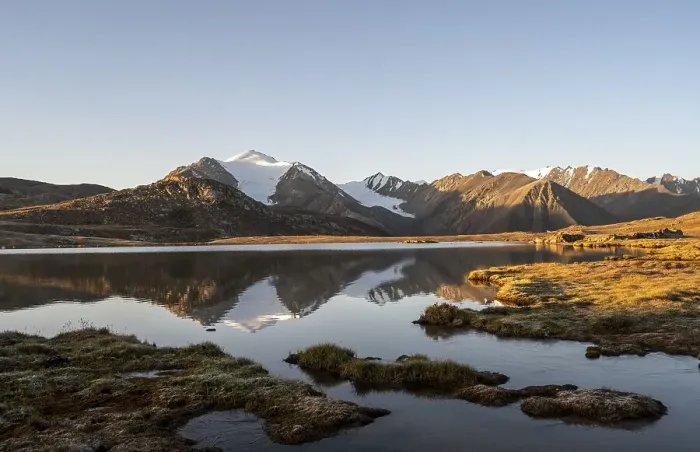 Framed Print : Glaciated mountain peaks reflected in a mountain lake at sunset