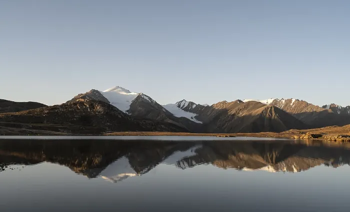 Framed Print : Glaciated mountain peaks reflected in a mountain lake at sunset
