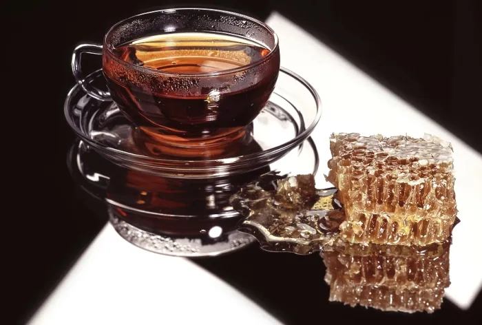 Framed Print : Glass cup of coffee and a piece of honeycombs on a glass background
