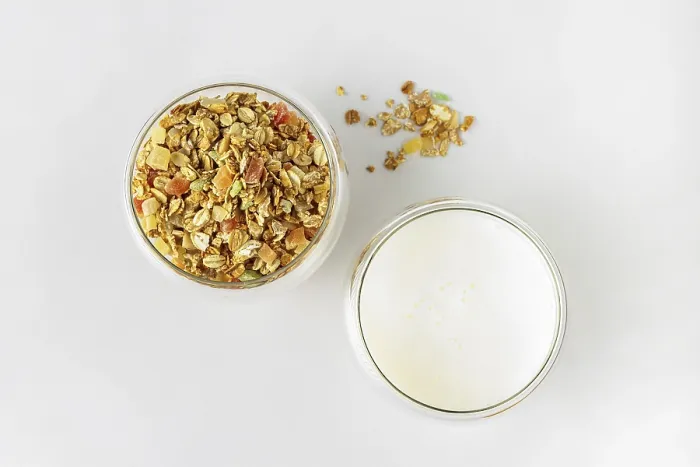 Framed Print : Glass with dry cereal and glass with yogurt on white background