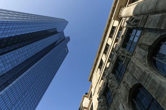 Framed Print : Glass facade of Deutsche Bank, next to it facade of an old house