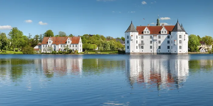 Framed Print : Glucksburg moated castle under a blue sky with white clouds Framed Print : Glucksburg moated castle under a blue sky with white clouds