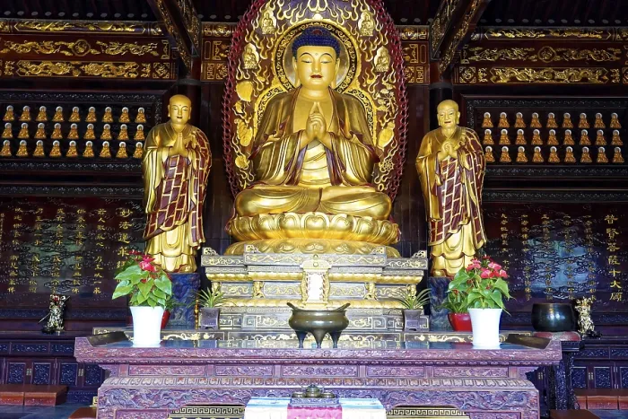 Framed Print : Golden Buddhist statues in a richly decorated worship room