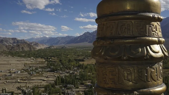 Framed Print : Detail of a golden prayer wheel against the backdrop of a vast mountain landscape Framed Print : Detail of a golden prayer wheel against the backdrop of a vast mountain landscape