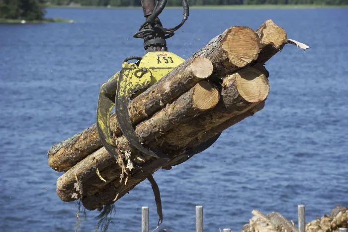 Framed Print : Grapple loading logs onto timber barge