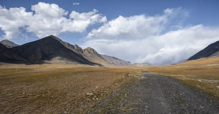 Framed Print : Gravel track on plateau, dramatic high mountains Framed Print : Gravel track on plateau, dramatic high mountains