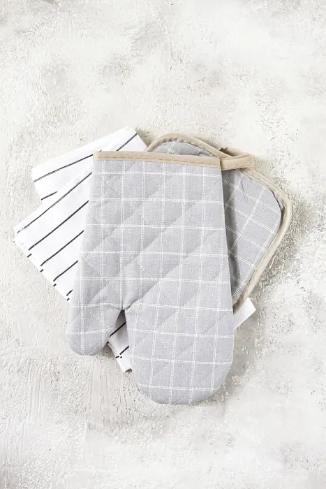 Framed Print : Gray checkered oven mitts and simple kitchen towels are neatly arranged on a soft Framed Print : Gray checkered oven mitts and simple kitchen towels are neatly arranged on a soft