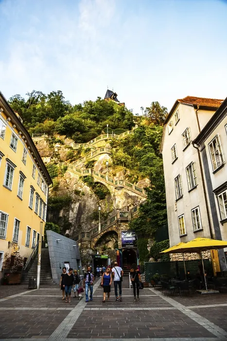Framed Print : Graz, Austria, 17.08.2019 : View at clock tower from street near steps over the hill