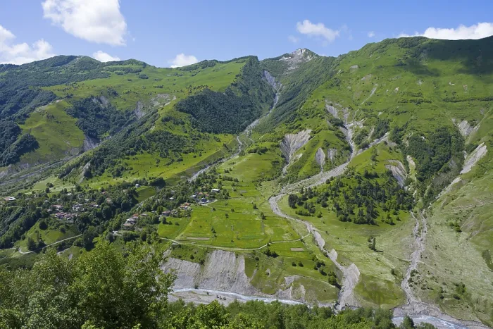 Framed Print : Green valley with mountains and river under blue sky and few clouds