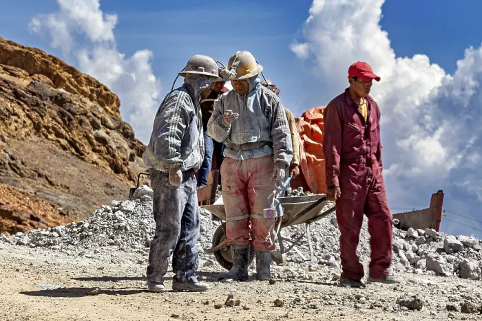 Framed Print : A group of miners stand and chat in a rocky landscape