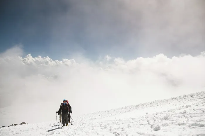 Framed Print : A group of mountaineers rises to the top of a snow-capped caucasian mountain against the backdrop of the rocky peaks of