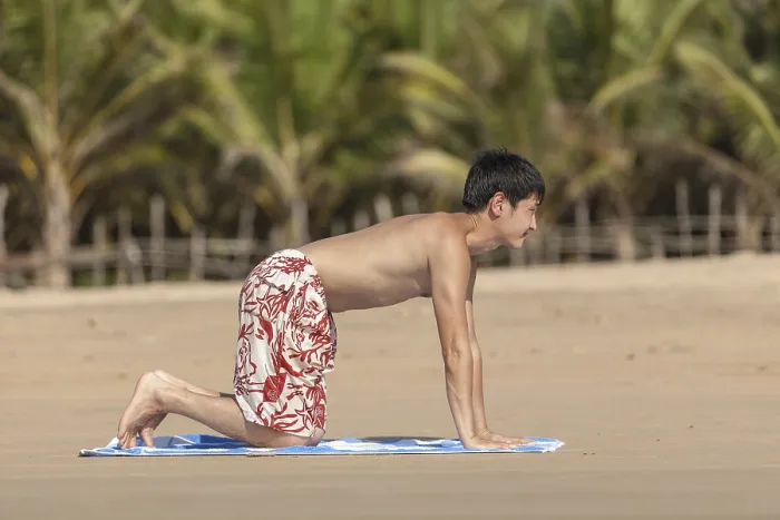 Framed Print : The guy of Asian appearance practices yoga on a beach against palm trees