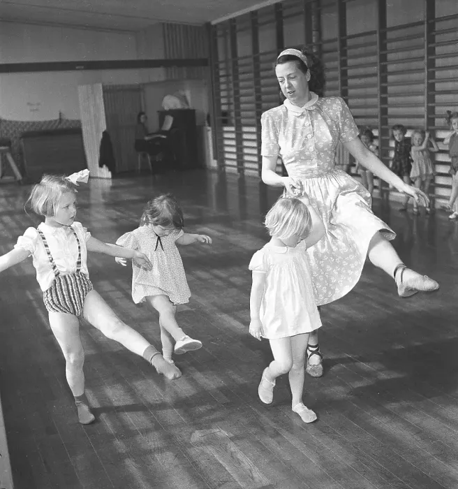 Framed Print : Gymnastics in the 1940s. A women teacher in the school gymnasium is showing how to move and dance