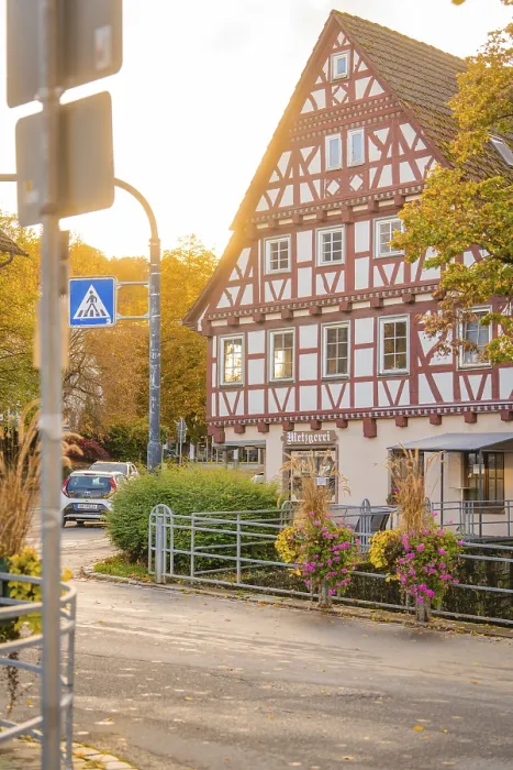 Framed Print : Half-timbered house in autumn surroundings with street lighting and flowers