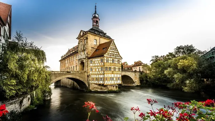 Framed Print : Half-timbered house on bridge over river with dramatic sky and sunset lighting