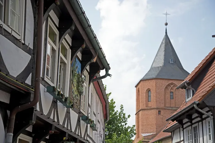 Framed Print : Half-timbered house next to a church