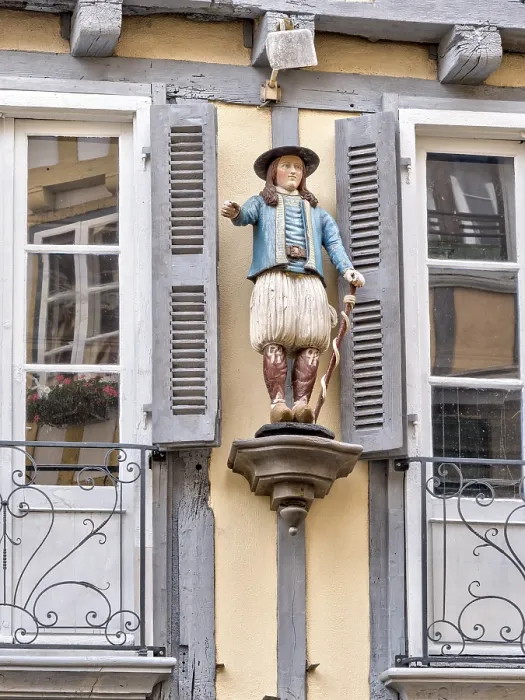Framed Print : Detail of the half-timbered house with statue of a man in historical traditional costume in the Rue Kereon