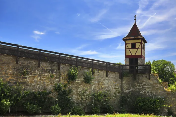 Framed Print : Half-timbered tower on high city wall under clear sky with surrounding greenery